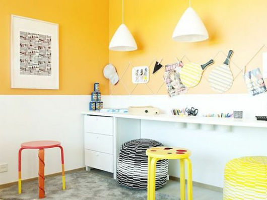 Zimmer mit Schreibtisch, Stuhl und Deko. In der Farbe Gelb gehalten.